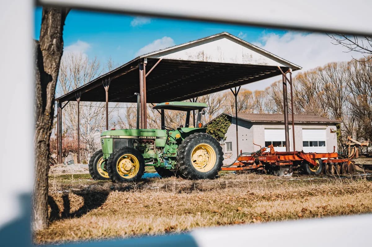 BookNoFees Beispielbild: Grüner Traktor unter einem offenen landwirtschaftlichen Schuppen