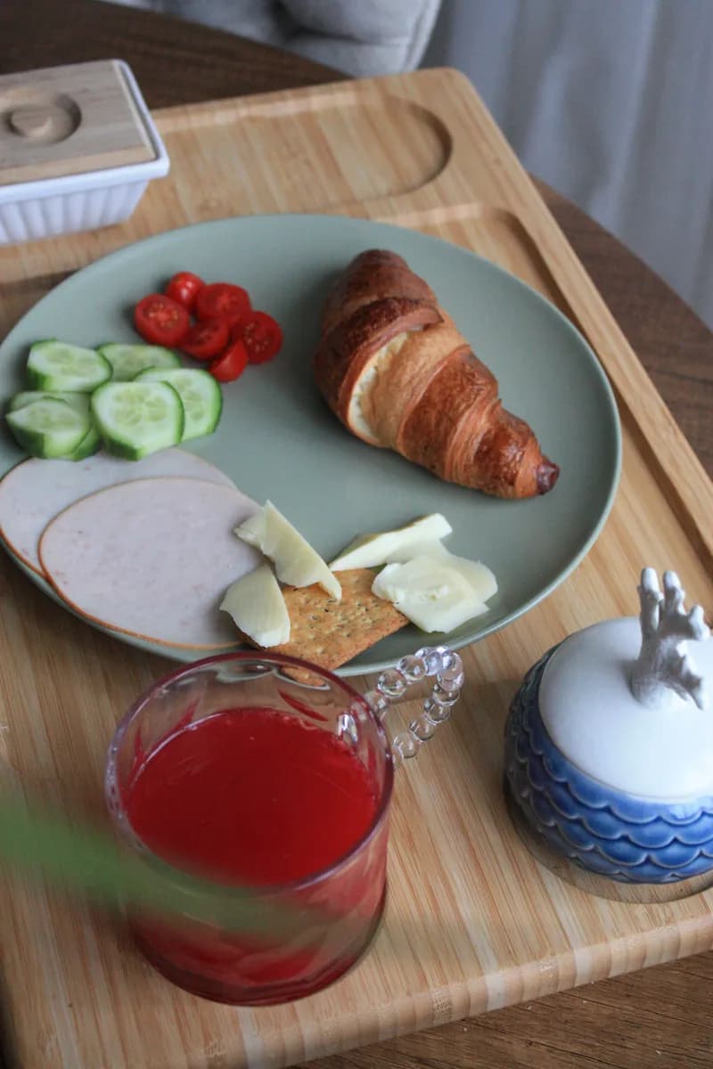 Exemple d'image BookNoFees : plateau de petit-déjeuner avec un croissant, des légumes et un jus de fruits