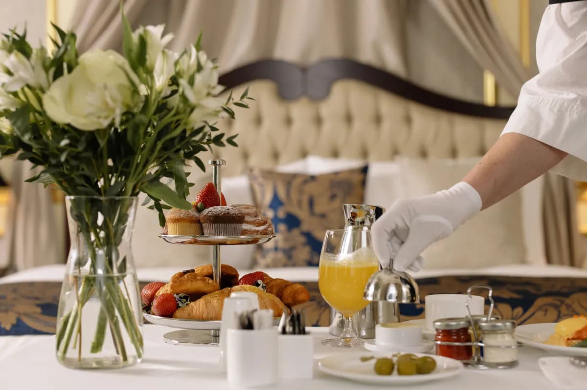 BookNoFees Beispielbild: Frühstückstisch mit Gebäck, Blumen und eingeschenktem Orangensaft
