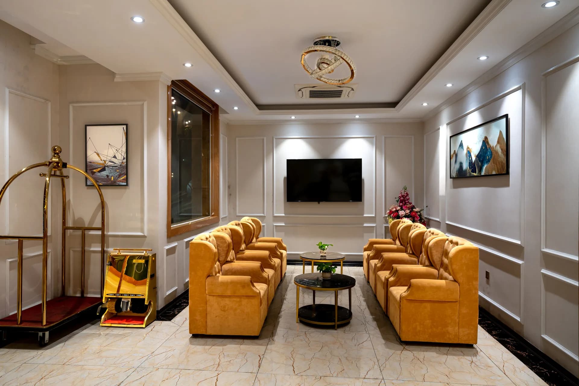 BookNoFees Beispielbild: Helle Hotellobby mit goldfarbenen Sesseln und Gepäckwagen
