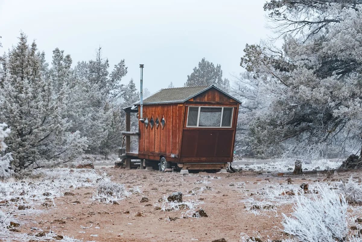 BookNoFees Beispielbild: Kleine Holzhütte auf Rädern in einer verschneiten Landschaft