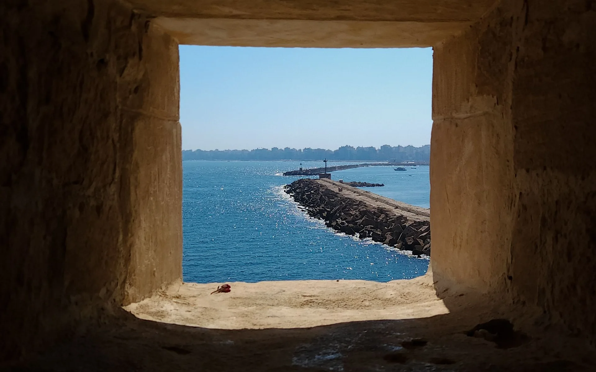Blick durch ein historisches Steinfenster auf das Meer in Alexandria