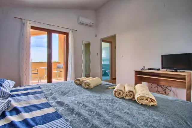 BookNoFees: Ferienwohnung in Štokovci, Kroatien – ein Schlafzimmer mit einem Bett, Handtüchern und einem Klavier in der Villa Stokovci in Štokovci