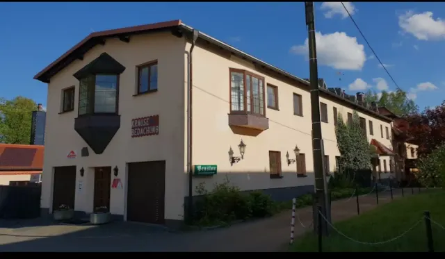 BookNoFees: Ferienwohnung in Schönfeld, Sachsen, Deutschland – Außenansicht eines zweistöckigen Gebäudes mit Garagentoren, Erkerfenstern und Straßenschild