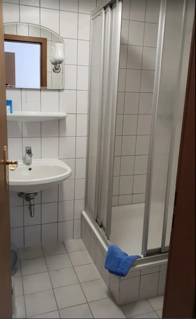 BookNoFees: Ferienwohnung in Schönfeld, Sachsen, Deutschland – Badezimmer mit weißem Waschbecken, Badewanne mit Duschwand und blauem Handtuch