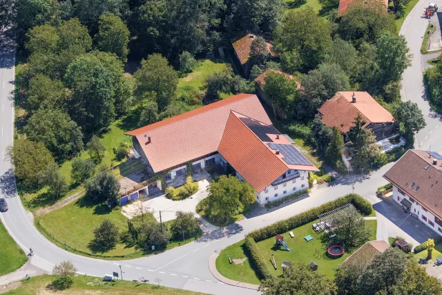BookNoFees: Ferienwohnung in Rimsting – Luftaufnahme eines Ferienhauses mit rotem Dach, Sonnenkollektoren und Spielplatz