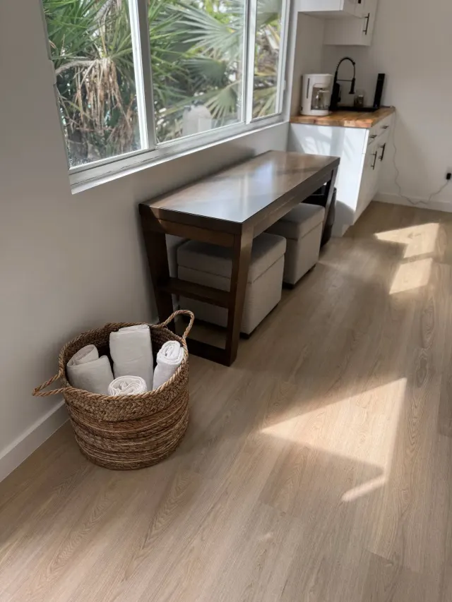 BookNoFees : location de vacances à Cutler Bay, États-Unis – Coin cuisine avec une table en bois, un panier tressé contenant des serviettes et une fenêtre donnant sur des palmiers