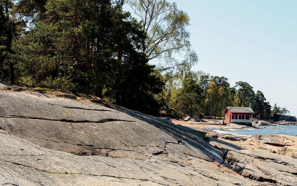 Rote Hütte an der felsigen Küste von Helsinki