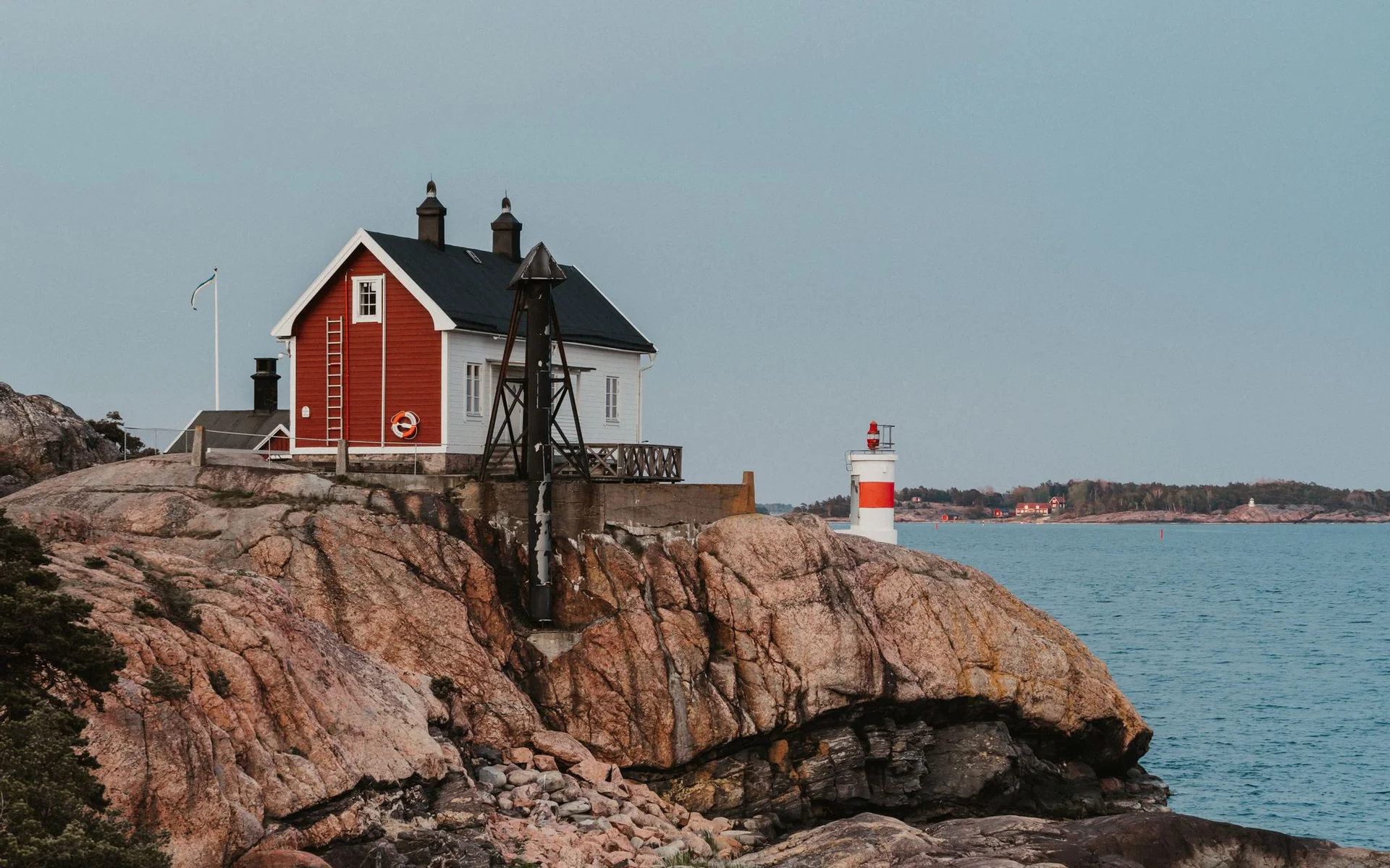 Maison rouge et phare sur la côte rocheuse suédoise