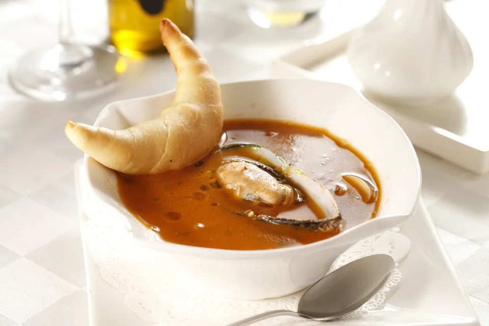 BookNoFees: Photo d’illustration : Soupe de fruits de mer servie avec du pain